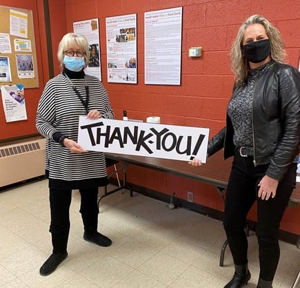 Community Care, St. Catharines & Thorold Receives $5,000 from McDougall Energy for the Holidays 102 Shows 2 women standing indoors with face masks holding a sign that says Thank You