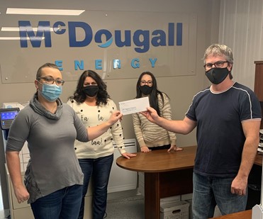 McDougall Energy donates $20,000 to Sudbury, Timmins and Manitoulin Organizations 94 Shows a group of 4 people standing and holding a cheque wearing face masks against wall with McDougall Energy logo