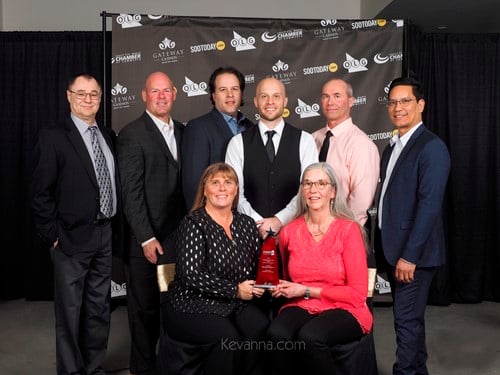 McDougall Energy Awarded Business of the Year from Sault Ste. Marie Chamber of Commerce 146 Shows 6 men standing and 2 women sitting in front of them smiling