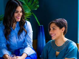 Customer Referral Rewards 1 two women in blue sitting together smiling
