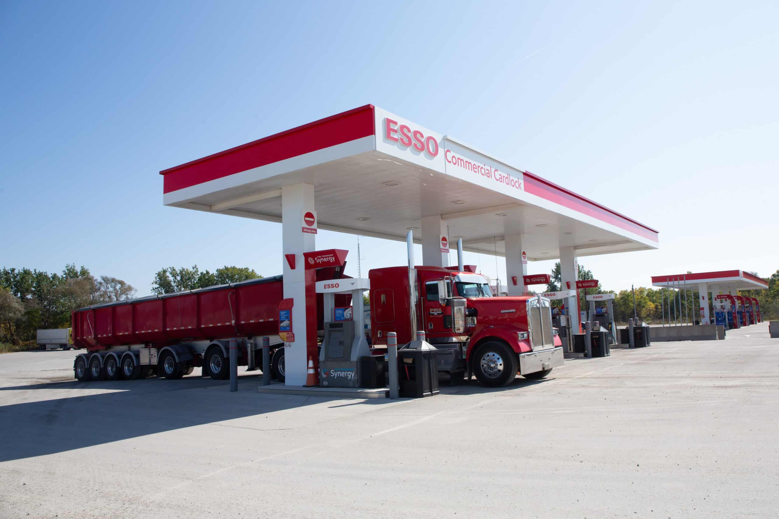 Clean fuel station with a red Semi-truck at Esso gas pumps, reliable fuel and energy services.