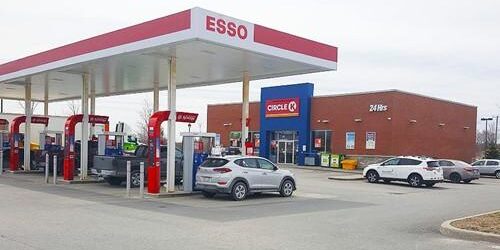 Shows exterior of Esso gas station and Circle K building behind it