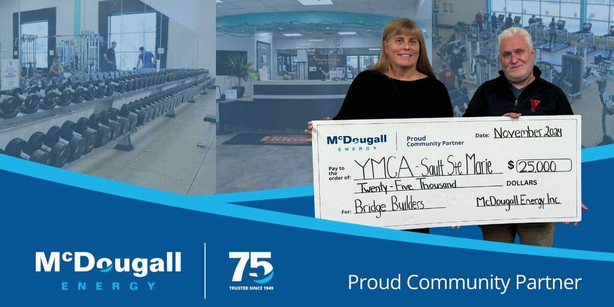 McDougall Energy team member poses with the YMCA staff with presentation cheque