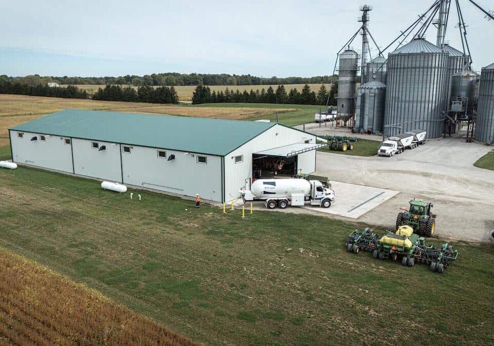 Propane storage tanks and agricultural silos at a rural fuel and energy facility.
