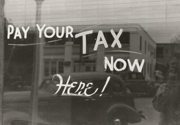 a sign that says pay your tax now here