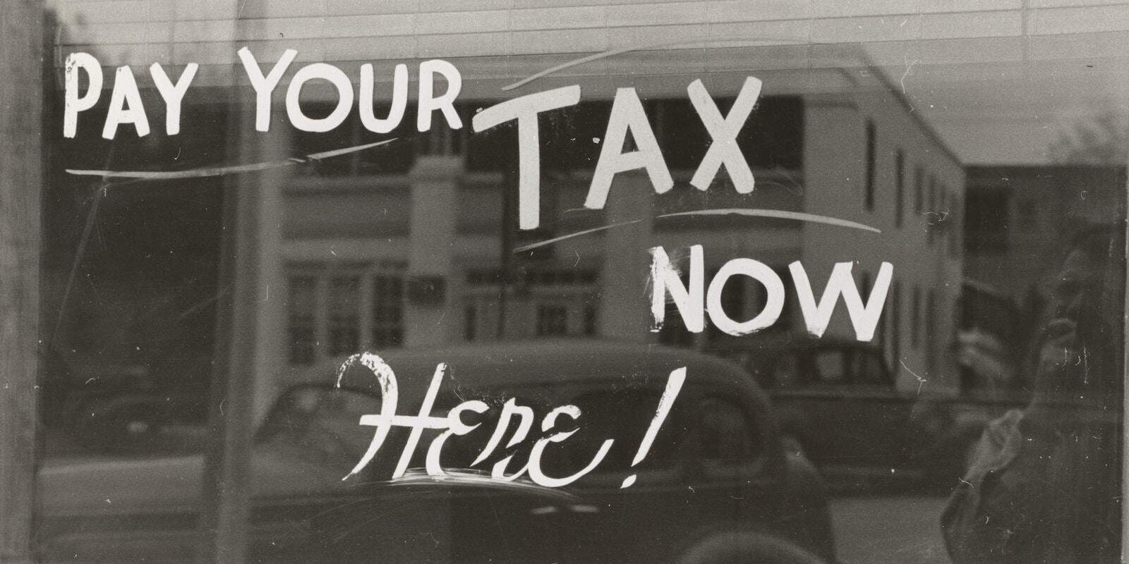 a sign that says pay your tax now here