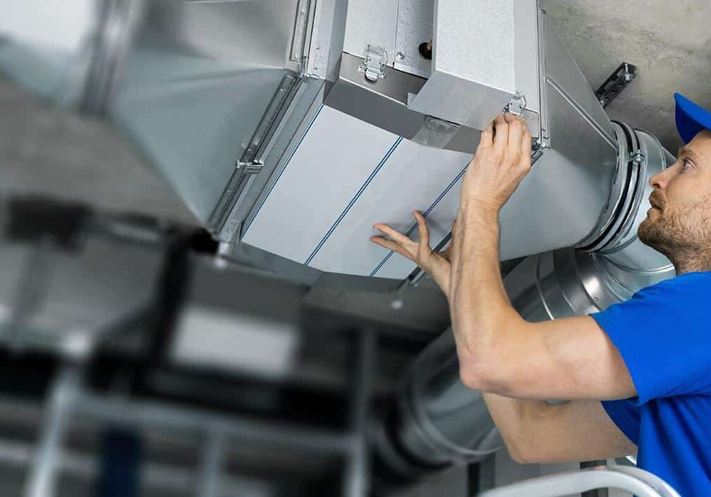 Energy technician inspecting industrial HVAC system for efficient heating and cooling solutions.