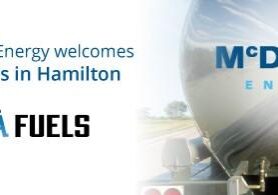 Shows back of a large chrome fuel truck with McDougall Energy logo and left of it is Vieira Fuels.