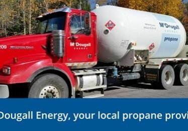Shows outside image of a large red and white McDougall Energy fuel truck
