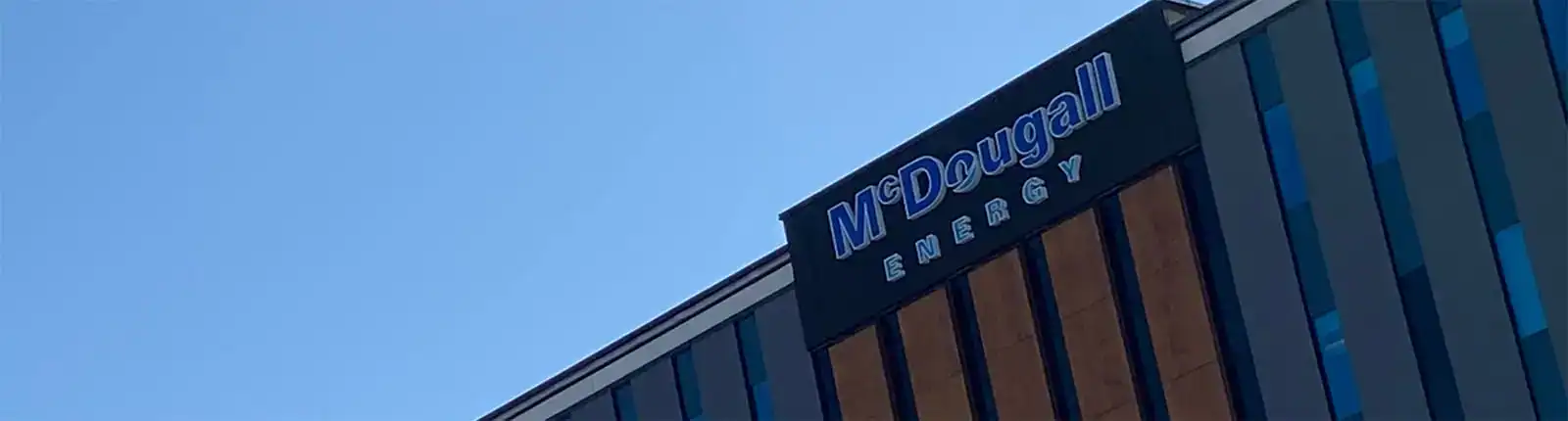 Energy company building with McDougall Energy signage in bright sunlight.