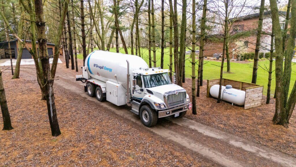 Fuel delivery made simple 3 McDougall truck on dirt road in rural area in surrounded by trees and fall leaves